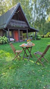 a picnic table and two chairs in front of a cabin at Wieża marzeń in Dąbrowa Grodzieńska-Wieś