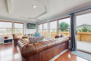 a living room with a leather couch and windows at Saltwater Shoreline in Shoreline