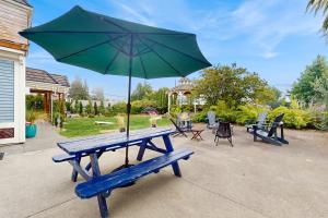 a blue picnic table with a green umbrella at Saltwater Shoreline in Shoreline