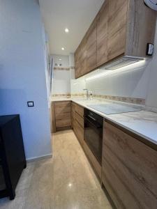 a kitchen with wooden cabinets and a stove top oven at Atico Benahavis in Benahavís