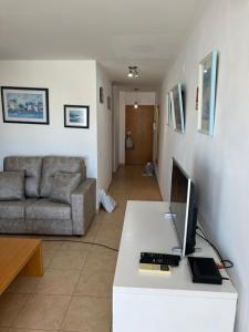 a living room with a desk with a computer and a couch at T1 Apartment Cabanas in Cabanas de Tavira