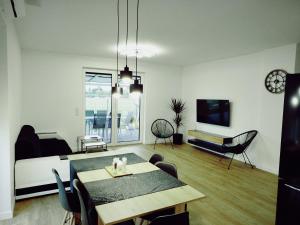 a living room with a dining table and a tv at Dom na Rzecznej in Schodnia Stara