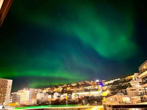 an image of the aurora in the sky over a city at Luxury Seaside Apartment Tromsø in Tromsø