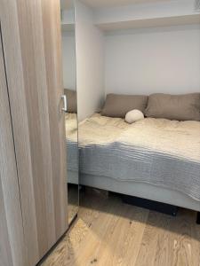 a small bedroom with a bed and a mirror at Luxury Seaside Apartment Tromsø in Tromsø