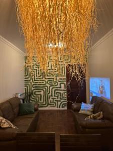 a living room with a couch and a large chandelier at Spacious & Artistic Apartment in Belém in Belém