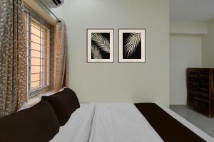 a bedroom with a bed and two pictures on the wall at Hotel O The Dream Inn in Pedda Ambarpet
