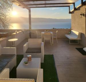 a patio with a table and chairs and the ocean at INCANTO Golden Place B&B in Reggio di Calabria
