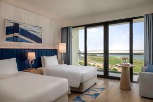 a hotel room with two beds and a large window at Crowne Plaza Yas Island by IHG in Abu Dhabi