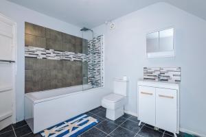 a white bathroom with a toilet and a sink at Hough Green Cottage in Ashley