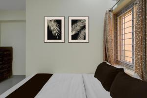 a bedroom with two pictures on the wall and a bed at Hotel O The Dream Inn in Pedda Ambarpet