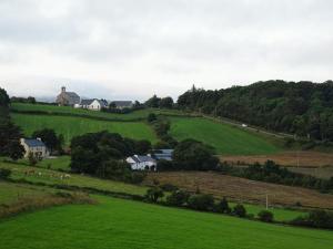 a green field with houses in the middle of it at Forrest view in Dunfanaghy