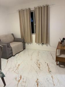 a living room with a couch and a marble floor at Apartamento albion in Porto Alegre +3 photos