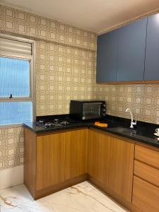 a kitchen with a sink and a microwave at Apartamento albion in Porto Alegre