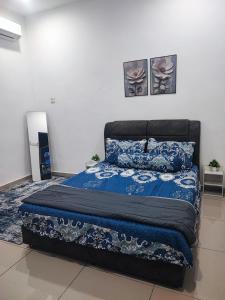 a bedroom with a bed with a blue comforter at QS Homestay Melaka in Melaka