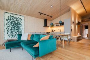 a living room with a green couch and a table at Moderni puuhuvila erämaan reunalla Kiilopäällä in Saariselka