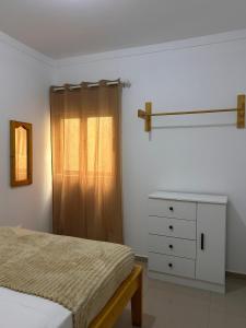 a bedroom with a bed and a dresser and a window at Sun & Sea Tarrafal in Tarrafal