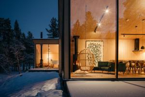a house with a view of a living room at Moderni puuhuvila erämaan reunalla Kiilopäällä in Saariselka