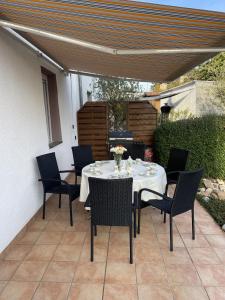 a table and chairs on a patio under an umbrella at Renovierte 85qm 6 PAX Altbauwohnung und Terasse - Apartment "Karin" in Riegelsberg +2 photos