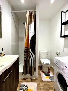 Un baño con inodoro y cortina de ducha. en Superbe T2 meublé - Style Jungle - Draguignan, en Draguignan 22 fotos más