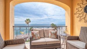 a balcony with a couch and chairs and the ocean at Princesa De Penasco in Punta Penasco New