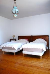 two twin beds in a room with wooden floors at La maison de l etang in Saint-Didier-sur-Arroux