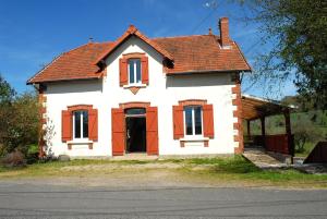 a white house with red windows and a roof at La maison de l etang in Saint-Didier-sur-Arroux
