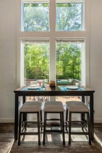 un tavolo da pranzo con 4 sedie e una grande finestra di High Hollow Cottage Modern Tiny Home with Hot Tub a Robbinsville