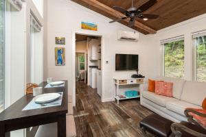 un soggiorno con divano e TV a schermo piatto di High Hollow Cottage Modern Tiny Home with Hot Tub a Robbinsville