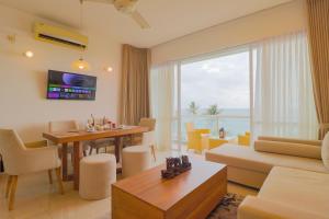 sala de estar con mesa, sofá y comedor en Savno Residency, en Uswetakeiyawa