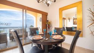 a dining room with a table and chairs and a balcony at Princesa De Penasco in Punta Penasco New