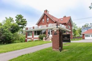 a brick house with a sign in the grass at Historic GG Barnum Mansion by Heirloom Boutique Collection in Duluth