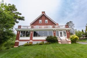 a large red brick house with a large yard at Historic GG Barnum Mansion by Heirloom Boutique Collection in Duluth +2 photos