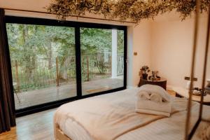 a bedroom with a bed with a large window at Woodhill Country House in Otterburn +15 photos