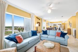 a living room with blue couches and a large window at Marlin Key 3A in Orange Beach