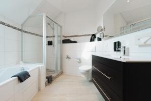 a bathroom with a tub and a toilet and a sink at Kaiserhof in Karlsruhe +46 photos