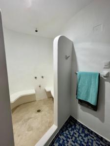 a white bathroom with a blue towel on the wall at Casa Je'elel Chuburna Puerto in Chuburná