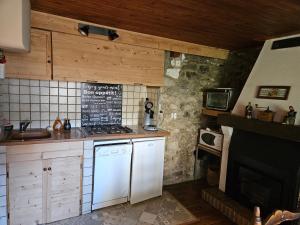 a kitchen with a white refrigerator and a stove at Maison de montagne in La Llagonne
