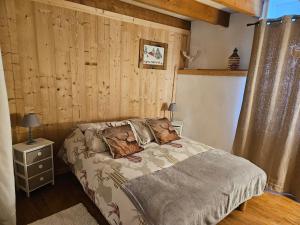 a bedroom with a bed and a wooden wall at Maison de montagne in La Llagonne