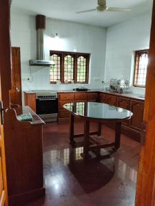 a kitchen with a table in the middle of it at Mansion Du Lac in Kottayam +12 photos
