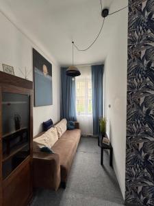 Una sala de estar con un sofá y un televisor. en Dom Gościnny Lublin, en Lublin