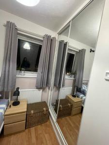 a bedroom with a mirror and a bed and a person in a window at Affordable Single Room in Saltney