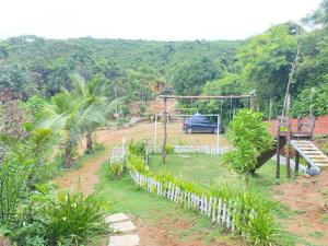 a view of a garden with a car in the background at Chalé refúgio das raposas in Meruoca +5 photos