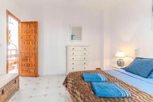 a bedroom with a bed with two blue pillows on it at RentitSpain Casa Estrella del Mar, a 400 metros de la playa in Castell de Ferro