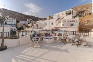 a patio with chairs and a table on a building at RentitSpain Casa Estrella del Mar, a 400 metros de la playa in Castell de Ferro