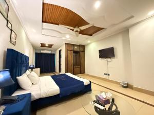 a hotel room with a bed and a tv at Atlas Gold Hotel in Islamabad