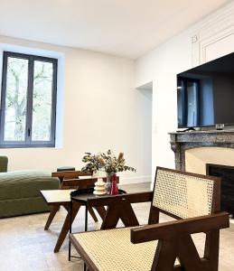 a living room with a table and a fireplace at DOMAINE De PLAISANCE in Cachen
