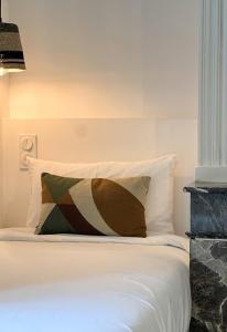 a white bed with a pillow on top of it at DOMAINE De PLAISANCE in Cachen