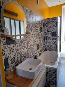 a bathroom with a white sink and a mirror at Au Jardin de Curé in Auxonne +1 photo