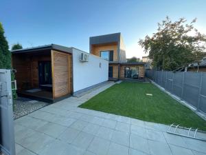a backyard with a lawn and a fence at Kub House in Bacău +6 photos
