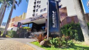 a sign for a hotel in front of a building at Slaviero Londrina Flat in Londrina